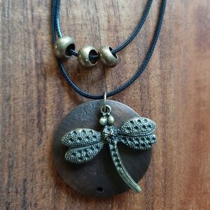 Elegant Dragonfly Pendant Necklace in Bronze against Wooden Circle